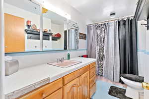 Bathroom featuring vanity, toilet, and tile walls