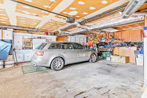 Garage featuring a garage door opener and white fridge