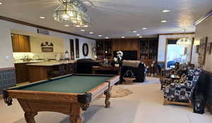 Playroom with billiards, ornamental molding, and light carpet