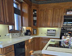 Kitchen featuring tasteful backsplash, sink, tile countertops, and black appliances