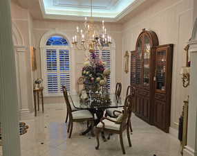 Marble floor formal dining space with crown molding and 14' raised ceiling. Built in China hutch that is back lighted.