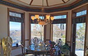 Dining area with an inviting chandelier, plenty of natural light, and ornamental molding