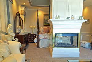 Sitting room with crown molding, a multi sided fireplace, and light carpet