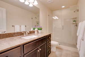 Bathroom with tile patterned flooring, vanity, toilet, and a shower with shower door