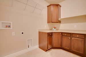 Washroom with cabinets, hookup for an electric dryer, and hookup for a washing machine