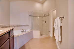 Bathroom with hardwood / wood-style flooring, vanity, and separate shower and tub