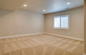 Carpeted empty room with a textured ceiling