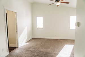 Unfurnished room with lofted ceiling, carpet floors, and ceiling fan