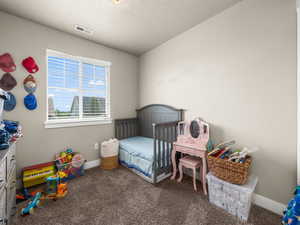 Carpeted bedroom with a textured ceiling