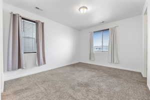 Unfurnished primary bedroom with carpet floors