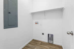 Laundry room featuring electric dryer hookup, hookup for a washing machine, dark wood-type flooring, and electric panel