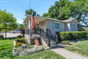 View of front facade featuring a front lawn and a porch