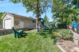 View of yard with a playground and a garage