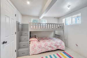 Tiled bedroom featuring beam ceiling