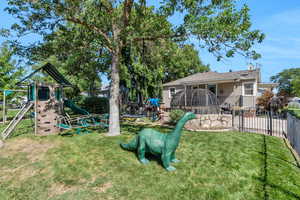 View of yard with a trampoline and a playground