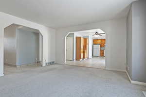 Empty room with light carpet and ceiling fan