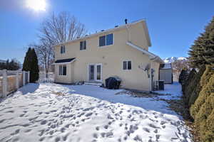 Snow covered rear of property featuring cooling unit and a mountain view