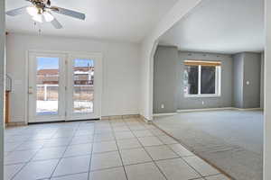 Tiled spare room featuring ceiling fan