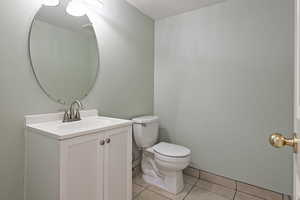 Bathroom featuring vanity, tile patterned floors, and toilet