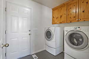 Clothes washing area with separate washer and dryer and cabinets