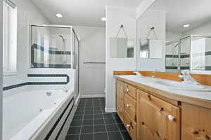 Full bathroom with tile patterned floors, toilet, independent shower and bath, and vanity