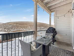 Snow covered back of property featuring grilling area