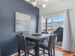 Dining area featuring a mountain view, a notable chandelier, and wood-type flooring