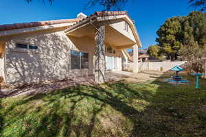 Rear view of house with a patio area and a lawn