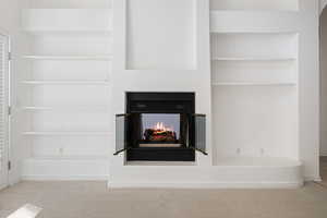 Interior details featuring a multi sided fireplace and carpet floors