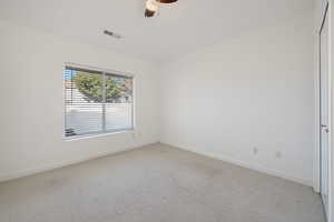 Carpeted spare room with ceiling fan