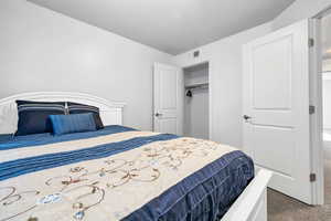 Carpeted bedroom featuring a closet