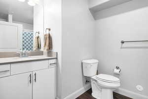 Bathroom featuring hardwood / wood-style flooring, vanity, and toilet