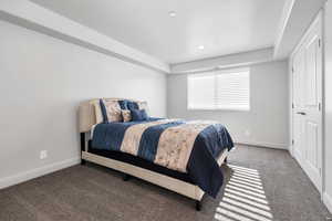 Bedroom with dark carpet and a textured ceiling