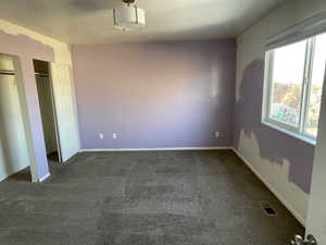 Interior space with dark colored carpet and two closets