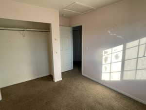 Unfurnished bedroom with dark carpet and a closet