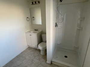 Bathroom featuring walk in shower, vanity, and toilet