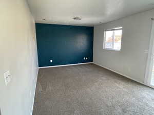 Carpeted spare room featuring a textured ceiling