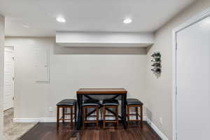 Dining area with dark hardwood / wood-style flooring, electric panel, and a textured ceiling