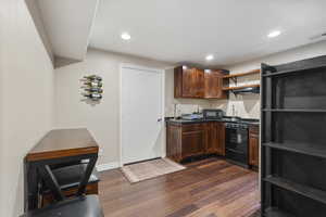 Kitchen with sink, dark wood-type flooring, and black appliances