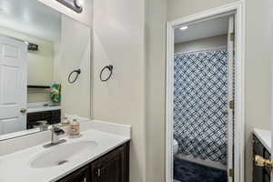 Bathroom featuring vanity, toilet, and a shower with shower curtain