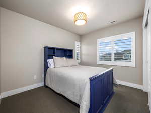 Carpeted bedroom featuring a textured ceiling