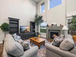 Living room featuring a towering ceiling and dark hardwood / wood-style flooring