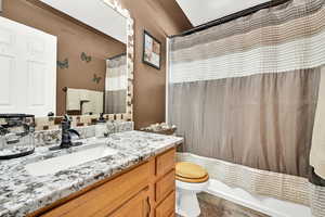 Full bathroom with vanity, toilet, and shower / tub combo