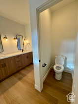 Bathroom featuring vanity, hardwood / wood-style floors, and toilet