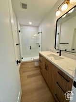 Bathroom with vanity, wood-type flooring, toilet, and walk in shower