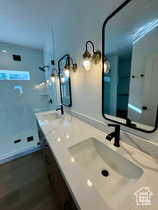 Bathroom featuring vanity, hardwood / wood-style flooring, and a shower