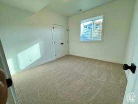 Unfurnished bedroom with light colored carpet