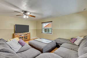 Living room with ceiling fan and light hardwood / wood-style floors