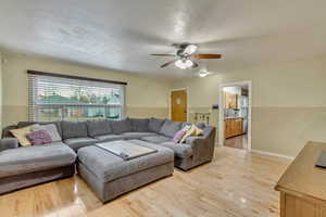 Living room featuring ceiling fan and light hardwood / wood-style floors