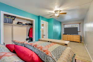 Bedroom featuring carpet floors, ceiling fan, and a closet